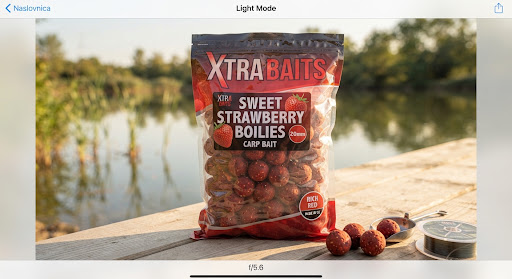 Bag of XTRA Sweet Strawberry boilies 20mm, rich red carp bait with strawberry seeds texture, displayed in warm natural lakeside light