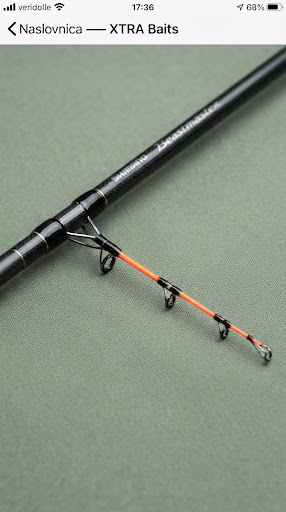 Shimano Beastmaster feeder fishing rod section with sensitive neon orange quivertip, studio photo on textured matte sage canvas